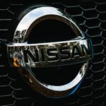 Detailed shot of the Nissan logo on a car grille grid, emphasizing automotive branding.
