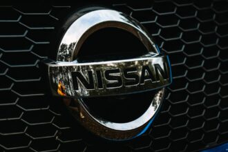 Detailed shot of the Nissan logo on a car grille grid, emphasizing automotive branding.