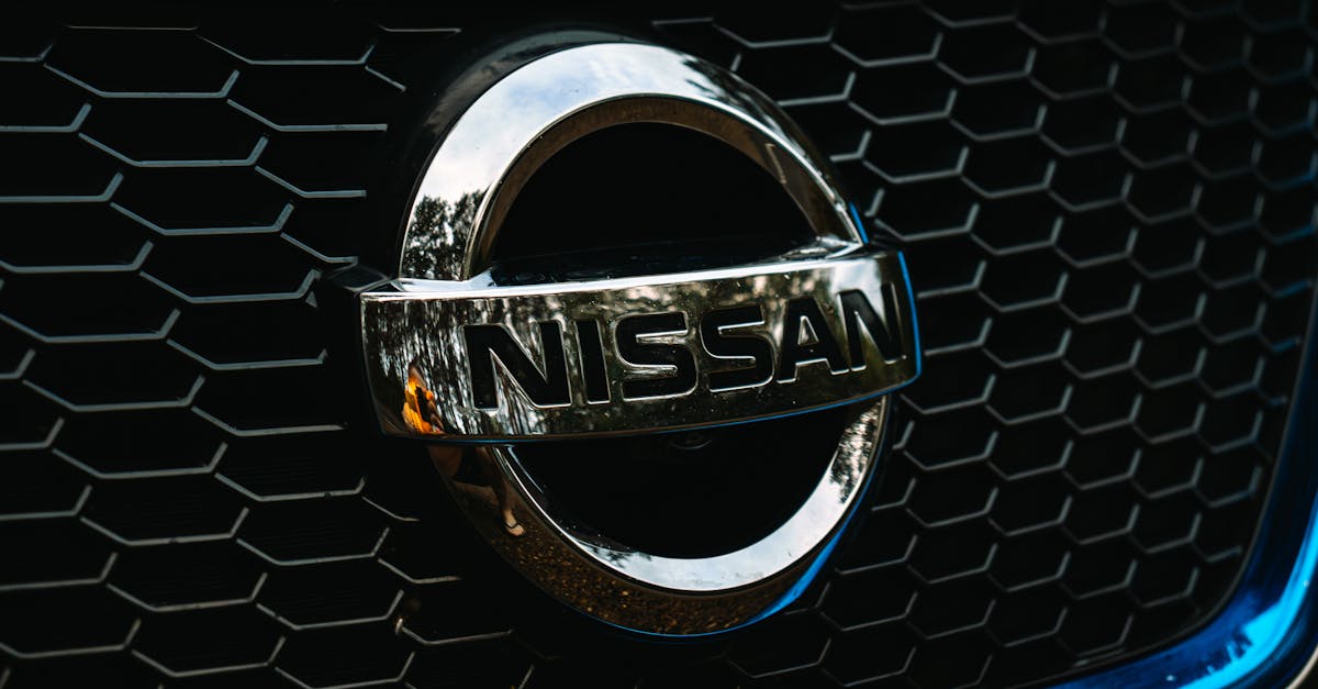 Detailed shot of the Nissan logo on a car grille grid, emphasizing automotive branding.